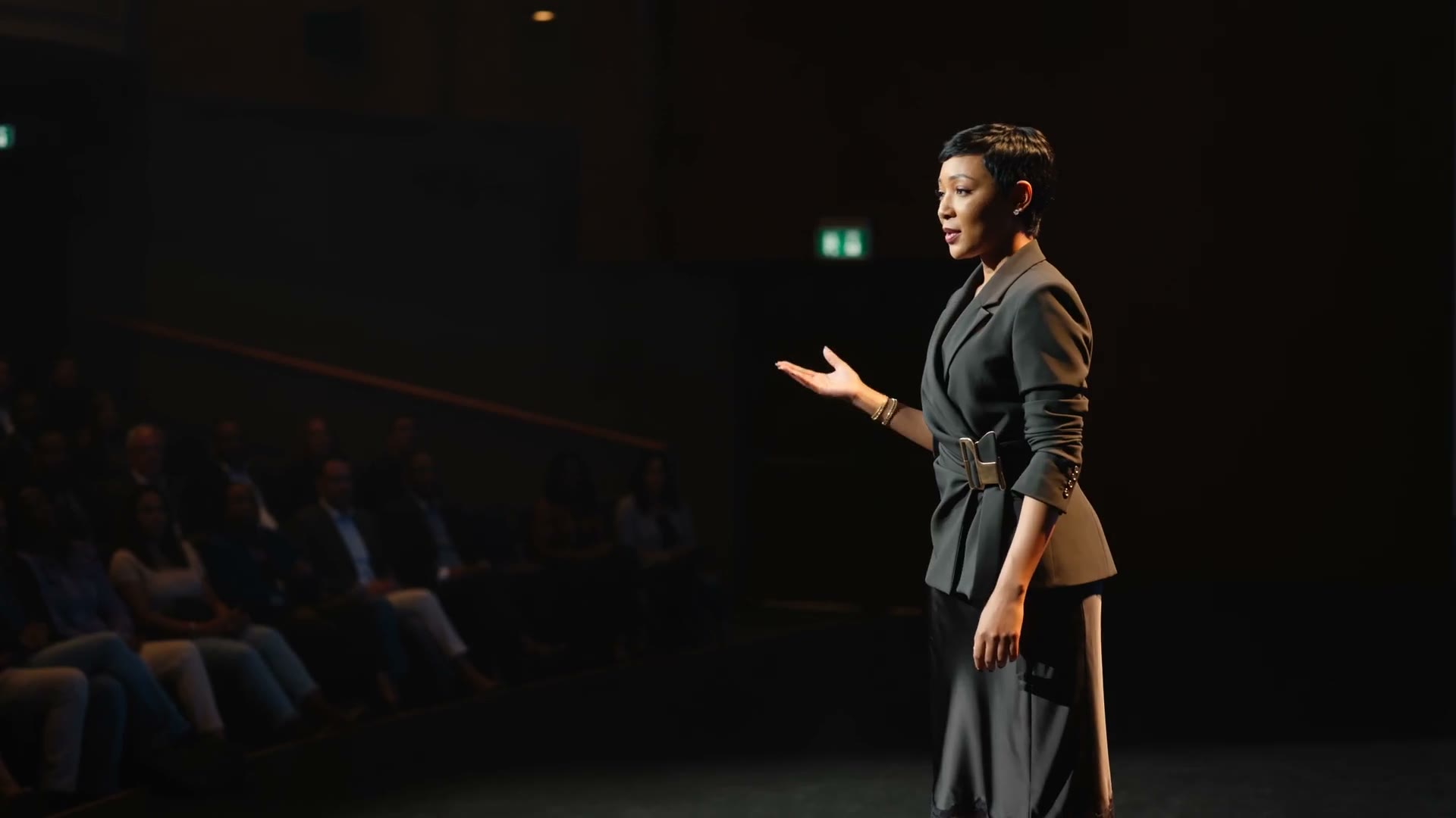 Yolanda Robert speaking on a stage before a seated audience