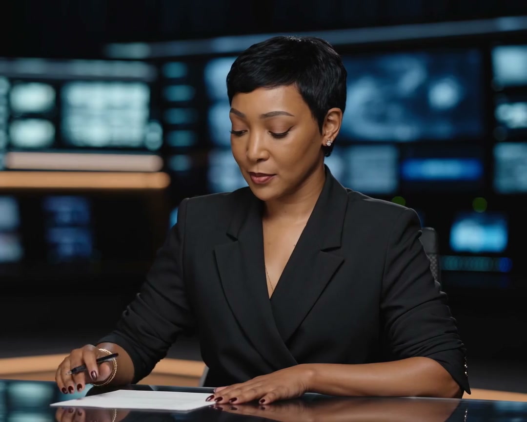 Yolanda Robert seated at a newsroom desk.