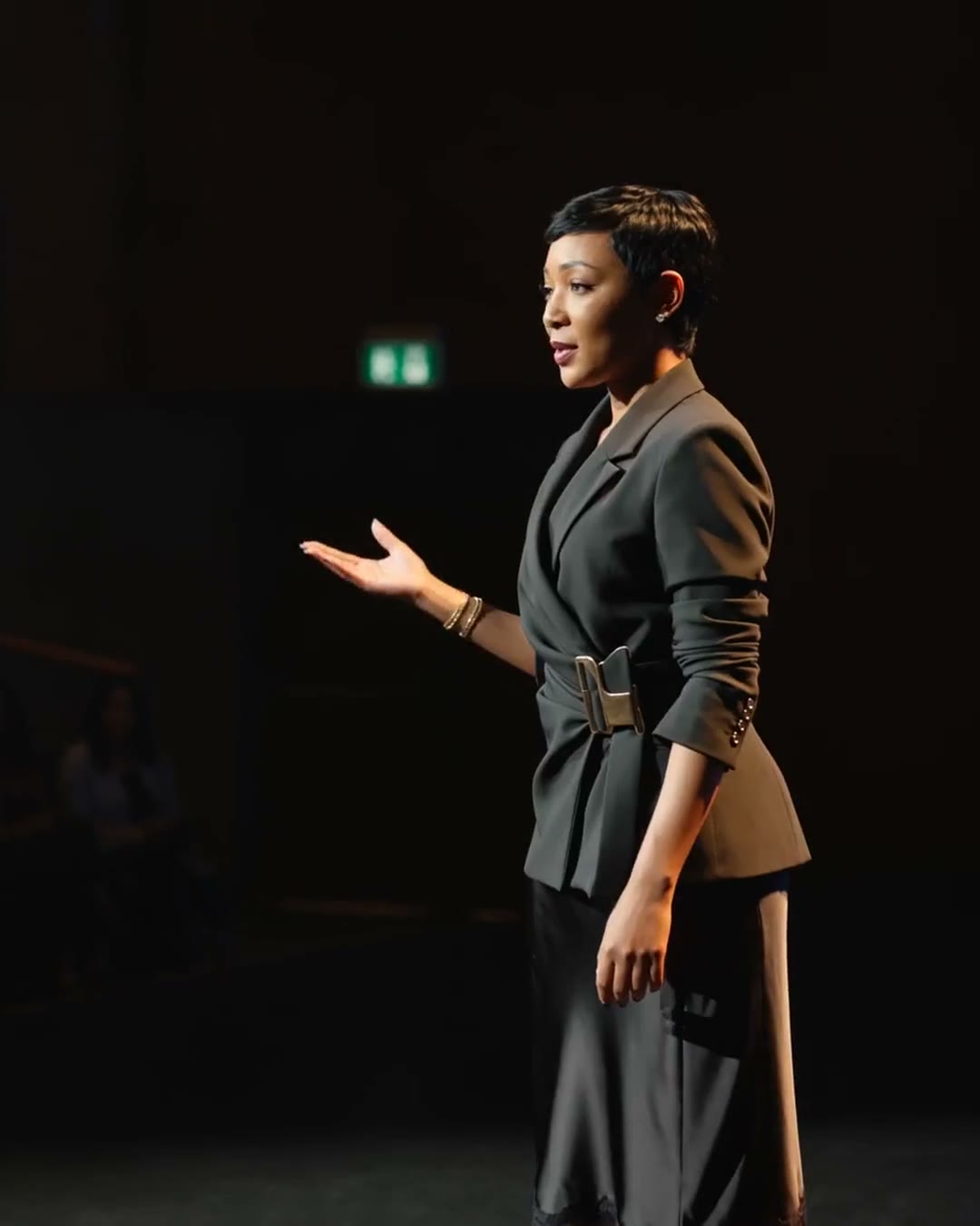 Yolanda Robert speaking on a stage before a seated audience